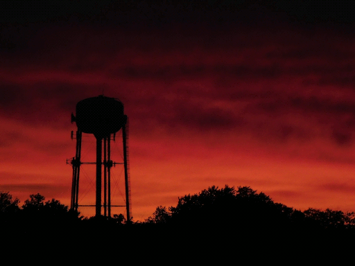 sky lit orange by sunset, water tower in silhouette (again)