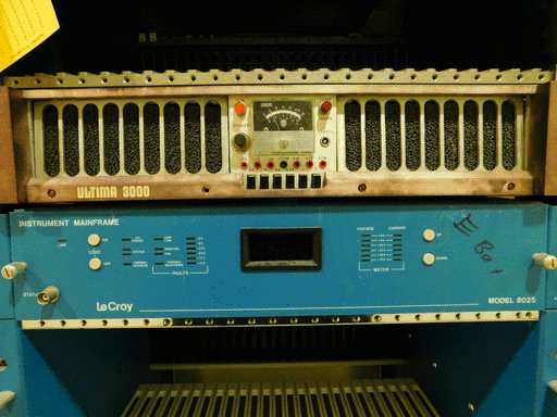 Zooming out, we see the numbers on the top bar run from 2-24 (wide side bars where 1 and 25 would be), and that the botom bar is labeled ULTIMA 3000 in a 70s science fiction paperback sort of font. Below the ULTIMA 3000 is another module, an azure LeCroy MODEL 8025 INSTRUMENT MAINFRAME with some silvery buttons, a bunch of rectangular display lights, a STATUS socket, and a rectangular window that presumably shows a segmented display when powered. The module has "E bay" written on it in sharpie. Above and below these two modules are empty spaces.