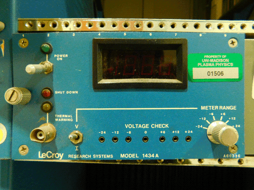 Close up of the left side of a different azure LeCroy modle, a MODEL 1434. It is a narrower rectangular panel, numbered 1-9 on its top edges. This one also has a window, and it is visibly a segmented display (one two-segment digit to display 1 and three full seven-segments) It has a POWER ON toggle switch with a painted line to a green light, a red SHUT DOWN light, and THERMAL WARNING socket / white light pair. There is a toggle switch between V and I, a bunch of sockets labeled VOLTAGE CHECK (-24, -12, -6, 0, +6, +12, +24), and a silver knob labeled METER RANGE with the same voltage levels marked, excepting 0.