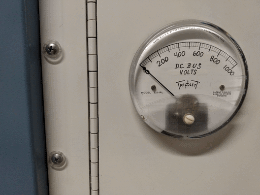 Close-up of the round Triplet voltmeter, measuring "D.C. BUS VOLTS" on a 0-1000 scale. The labeling looks handwritten.